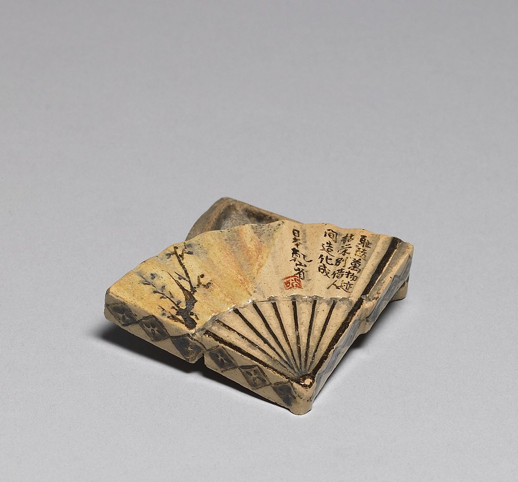 1024px-Ogata_Kenzan_-_Incense_Box_in_the_Shape_of_a_Folding_Fan_-_Walters_491372_-_Open.jpg